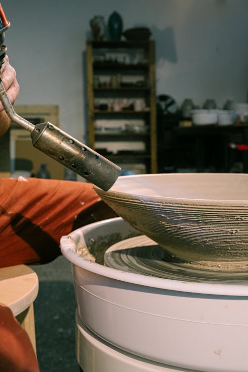 Person Drying a Clay Bowl With Blow Torch