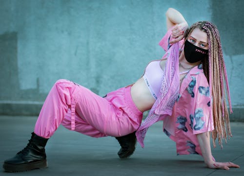 Stylish female breakdancer in mask on street