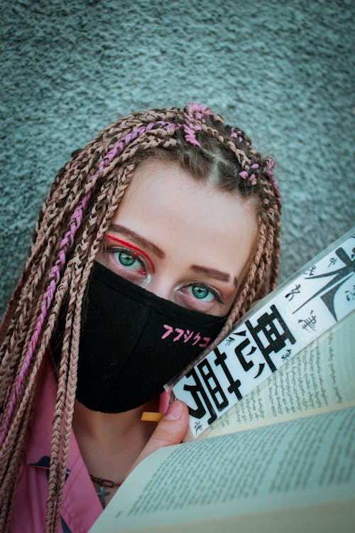 Modern woman in safety mask with book