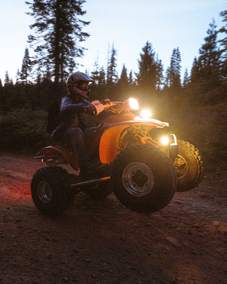 Man Riding A Quad Bike On Dirt Road