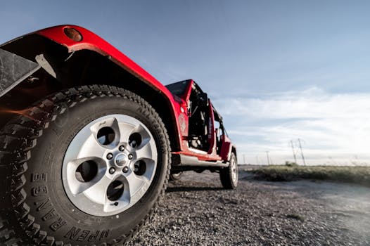 A red all-terrain vehicle parked on a rural path under clear blue skies