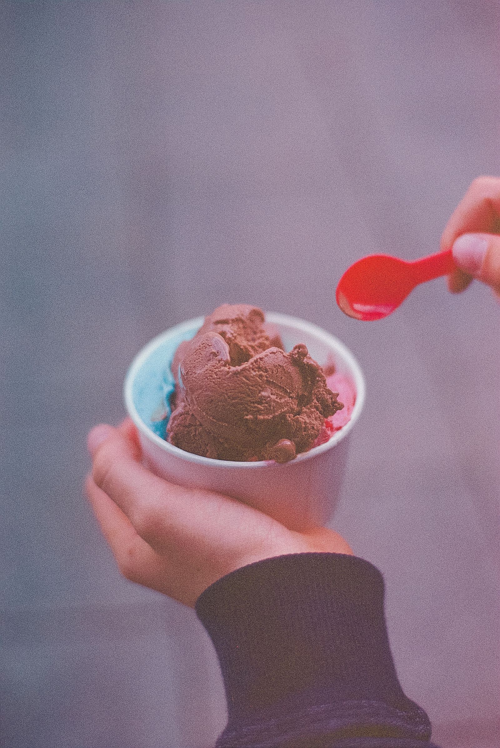 Person inspecting a cup of ice cream before eating it