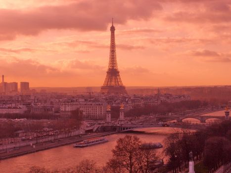 A stunning aerial view of Paris featuring the iconic Eiffel Tower during a vibrant sunset.