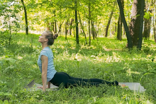 A woman doing yoga on a mat in a serene forest setting, promoting relaxation and fitness.