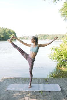 Healthy lifestyle with yoga by a serene lake during summer. Perfect for outdoor exercise enthusiasts.
