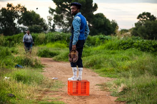 A Man Standing on Orange Crate