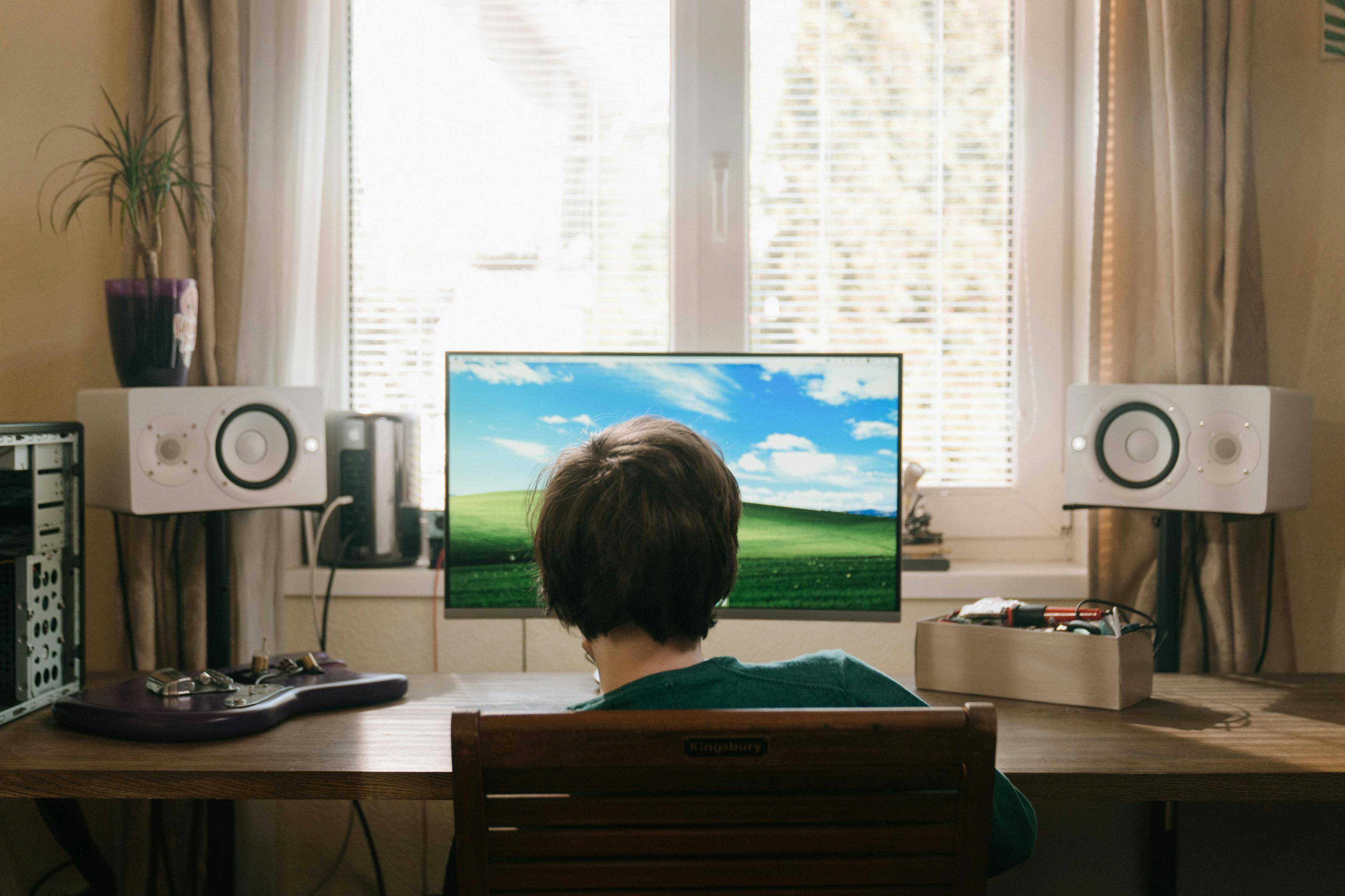 Boy in Red Shirt Sitting on Chair in Front of Black Flat Screen Tv · Free Stock Photo