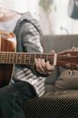 Person Playing Brown Acoustic Guitar