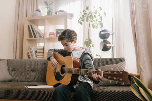 Free Man in Gray Long Sleeve Shirt Playing Brown Acoustic Guitar Stock Photo