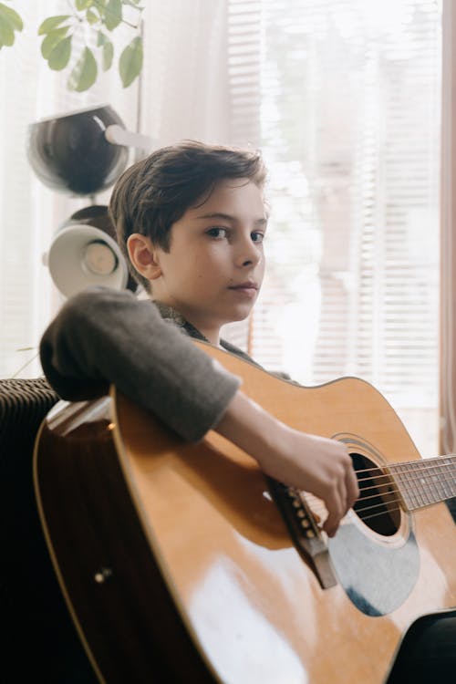 Free Boy in Gray Long Sleeve Shirt Playing Brown Acoustic Guitar Stock Photo