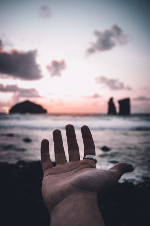 A Man Extending his Hand Towards the Sea