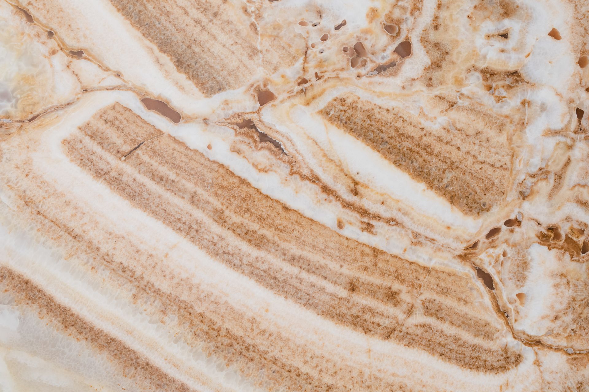 Detailed close-up of brown and white marble texture, showcasing natural cracks and patterns.