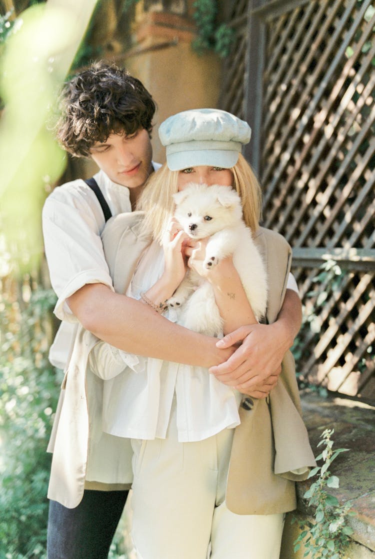 Couple Posing With Their Puppy