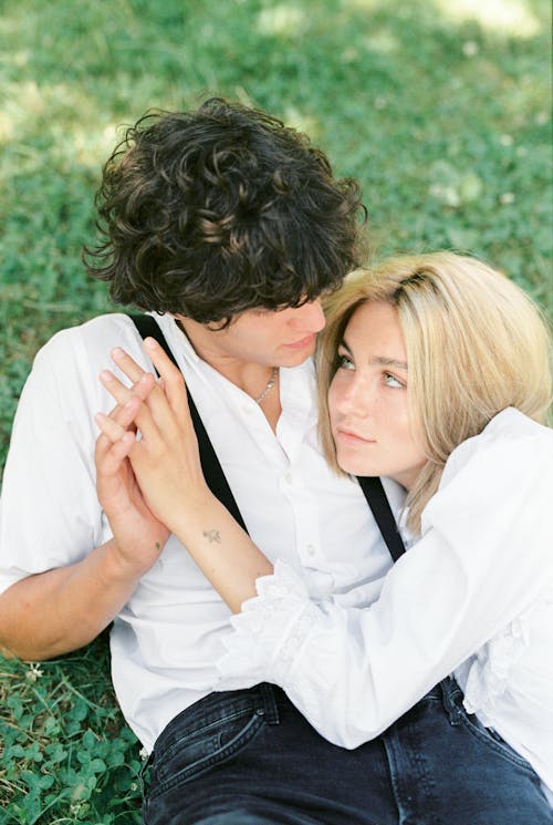 Мужчина и женщина, целующиеся на поле зеленой травы