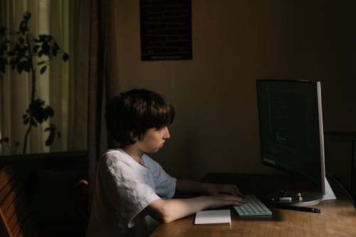 Boy in White T-shirt Using Laptop Computer