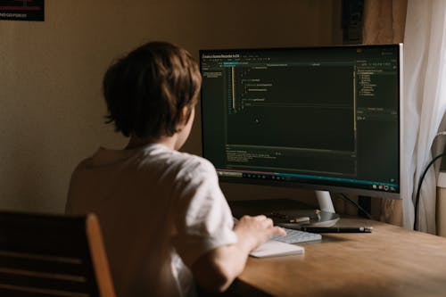 Free Person in White Shirt Using Computer Stock Photo