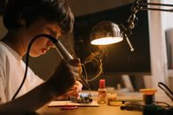 孩子在车间里专心用工具焊接电子电路板
