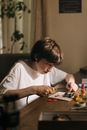 一个小男孩正专注地在桌子上用各种电子工具焊接印刷电路板