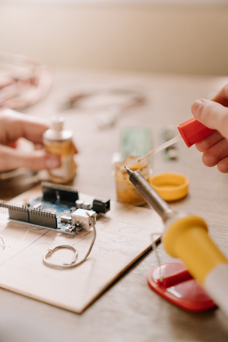 Person Holding Red And Yellow Plastic Tool