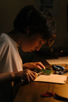 一个小男孩正专注地在办公桌前焊接印刷电路板
