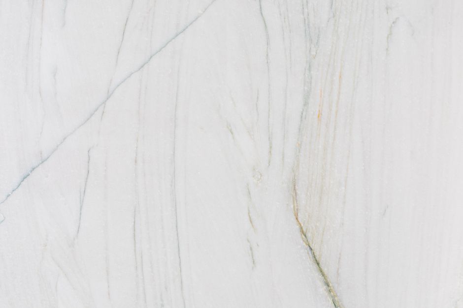 High-resolution image of a smooth white marble surface with gentle veining, ideal for design and decor.