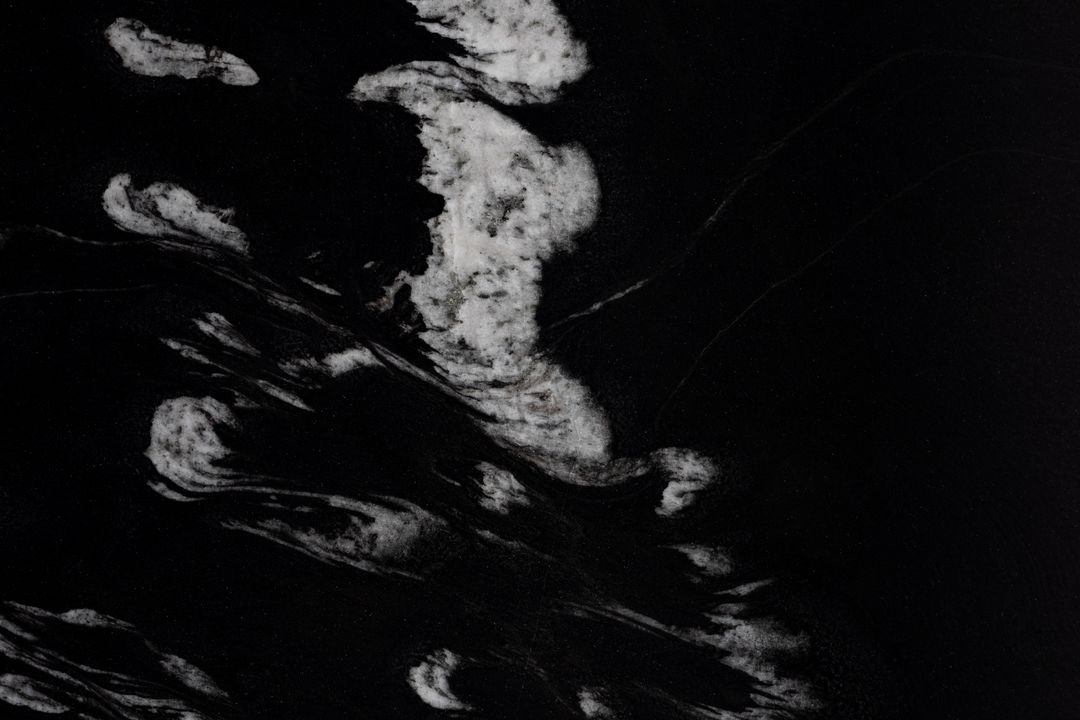 Close-up of dense black stone with white mineral veining, texture standing in for the density of a hard-wearing ring material