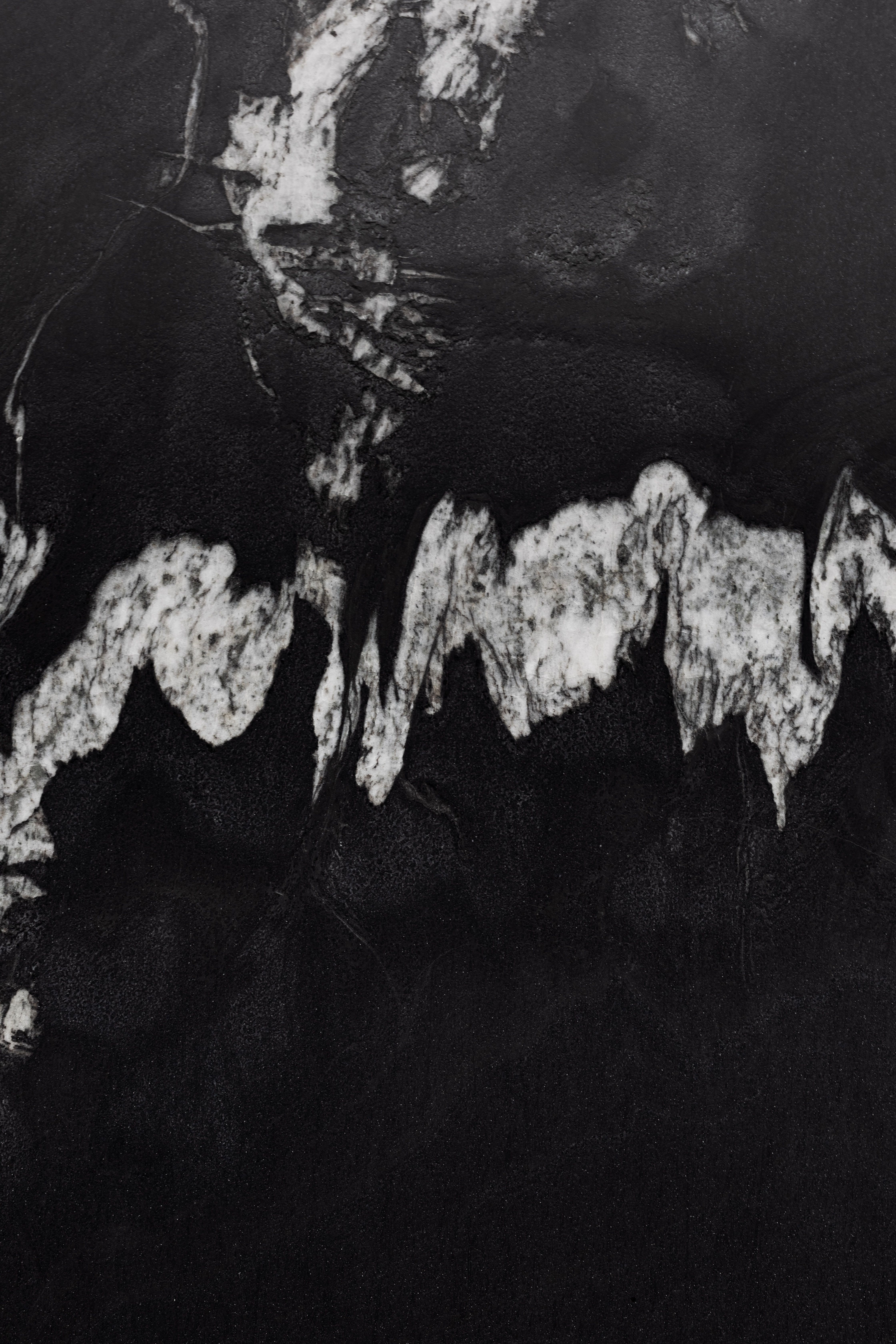 Abstract texture of black and white marble reminiscent of a cave's surface.