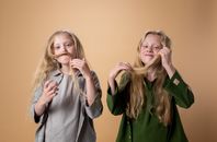 Woman in Gray Coat Holding Girl in Green Shirt