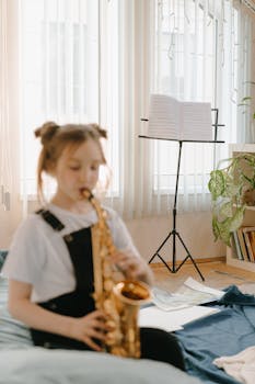 A young girl playing saxophone indoors, creating a musical ambiance.