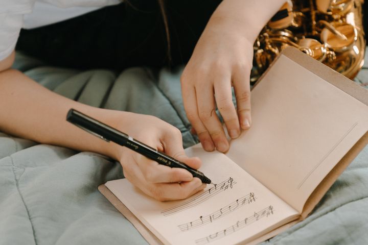 Woman in White Shirt Holding Pen Writing on White Paper