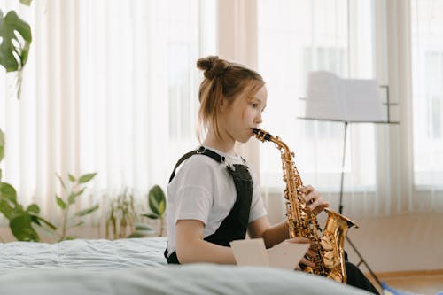 Girl in White and Black Shirt Playing Saxophone