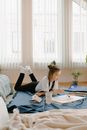 Woman in White Long Sleeve Shirt Sitting on Bed