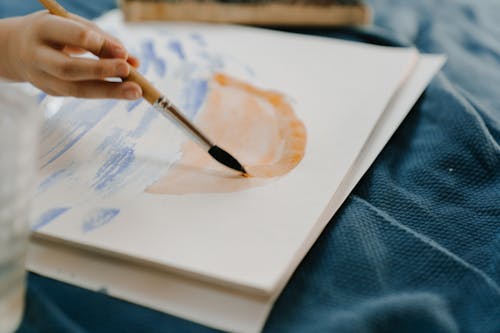 Person Holding Black Pen on White Paper