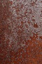 特写镜头展示了生锈金属表面的大地色调纹理化腐蚀图案