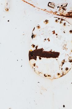 特写视图：白色背景上生锈且磨损的金属表面，带有螺栓