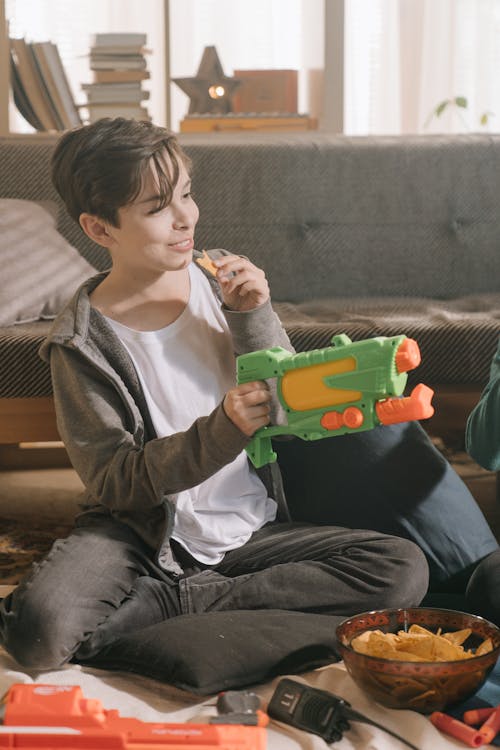 Boy in White Crew Neck Shirt and Gray Jacket Playing Green Toy Car