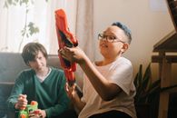 Boy in White Crew Neck T-shirt Holding Red and Black Hand Tool