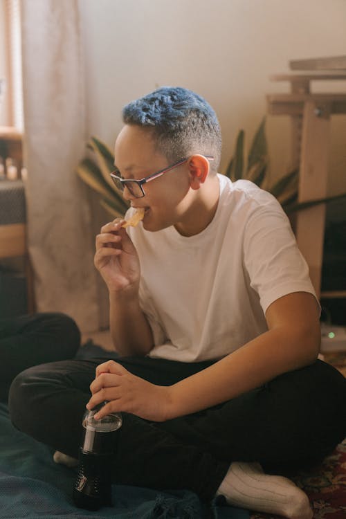 Man in White Crew Neck T-shirt Wearing Eyeglasses Sitting on Black Sofa