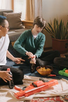 Teenagers gather indoors enjoying snacks and soda with toys, exuding a relaxed, fun atmosphere.