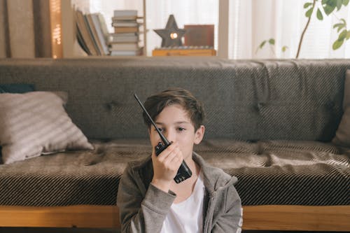 Boy in Gray Jacket Holding Black Smartphone