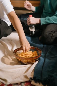 年轻的朋友们在舒适的室内环境中分享小吃和饮料，享受友谊与休闲时光