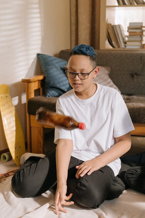 Man in White Crew Neck T-shirt Sitting on Brown Wooden Armchair