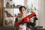 Boy in Gray Sweater Holding Red Plastic Toy Gun