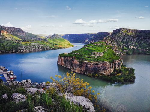Free Aerial view of a vibrant green island amidst rocky cliffs and blue waters in Gaziantep, Türkiye. Stock Photo