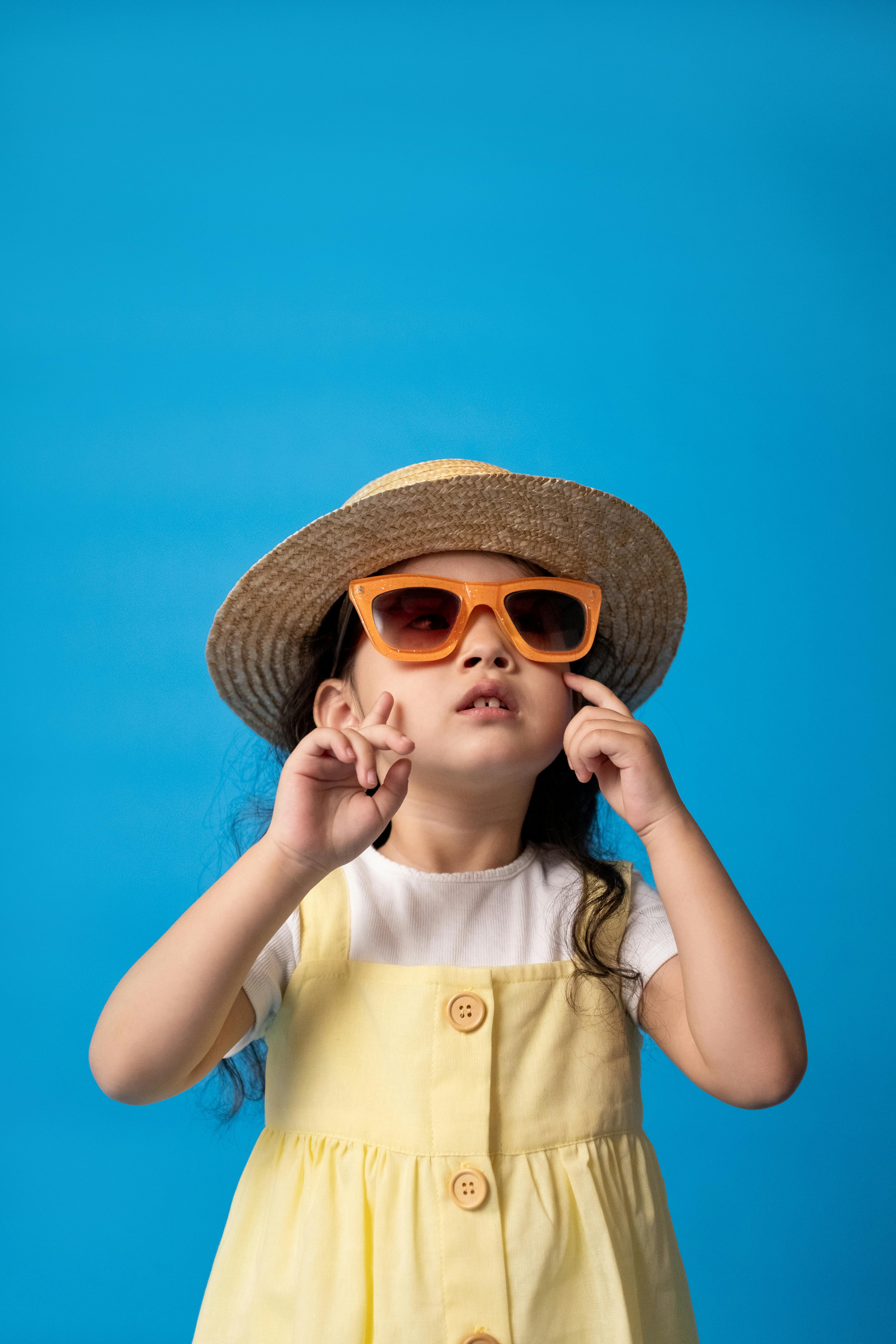 woman in white button up shirt wearing brown sun hat and sunglasses