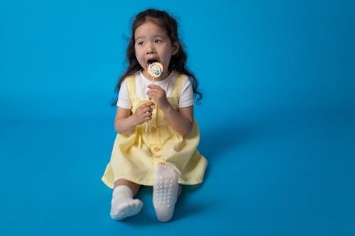 Meisje In Gele Jurk Met Witte En Roze Fopspeen