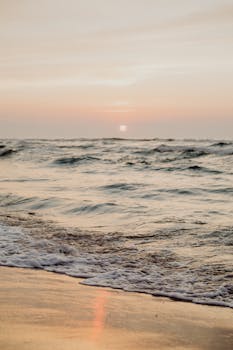 A calming ocean sunrise with gentle waves and a sandy beach, perfect for relaxation themes.