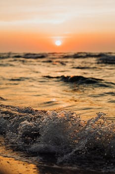 Stunning sunset view over the waves at Karwia Beach, Poland, capturing the tranquil beauty of the evening sea.