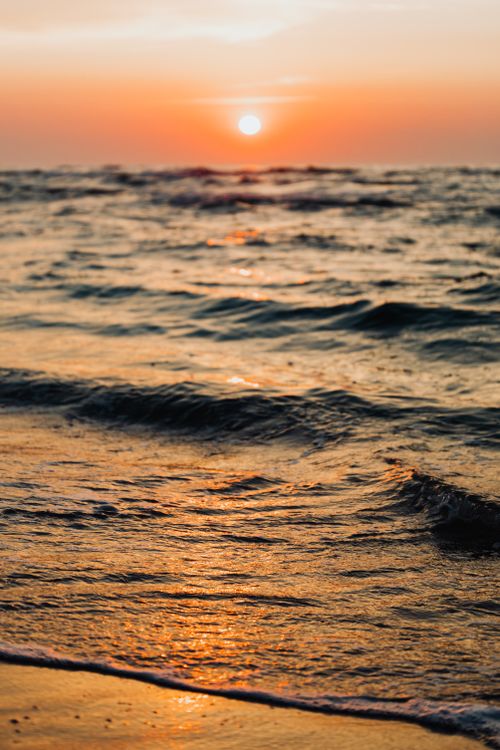 Free Captivating sunset over the Baltic Sea with gentle waves and golden reflections on the shore. Stock Photo