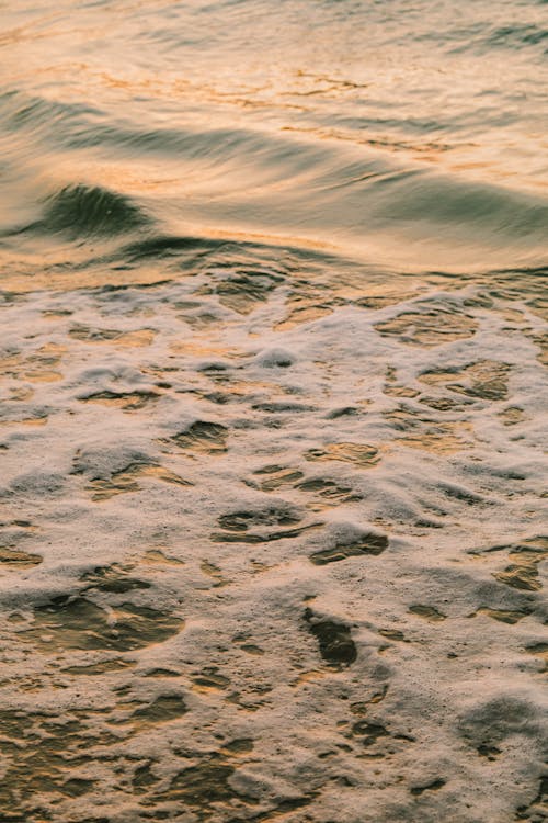 Free Bubbly Water Waves on Gray Sand Stock Photo